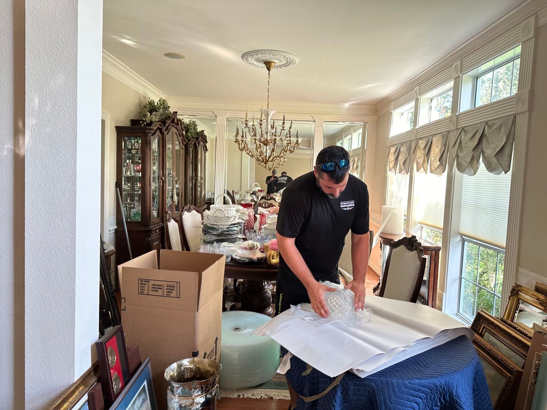 A man is wrapping a piece of paper in a living room.