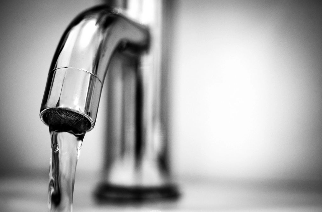 Water running from a silver kitchen faucet